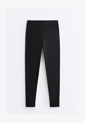 Črne slim-fit hlače z žepi spredaj, ravnim krojem hlačnic in srednje visokim pasom, položene ravno na belem ozadju.