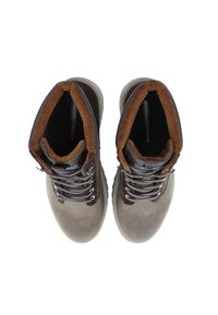 Bruna läderankelstövlar har en krage i brun manchester, grå snören och en texturerad gummisula. Ovanifrån visas en symmetrisk design.