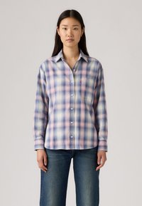 Geruite shirt in lichtpaars, blauw en crème tinten; heeft een knoopsluiting, kraag en een enkele borstzak. Zachte stof met lange mouwen.