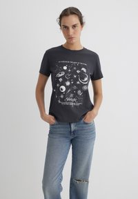 Short-sleeve, dark gray cotton t-shirt featuring a celestial print in white, including planets and stars, with text below the design.