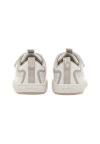 Zapatillas beige con detalles perforados, materiales superpuestos y tiradores en la parte trasera. Presenta un logo sutil y líneas de acento en contraste.