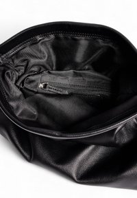 Juoda odinė rankinė su minkšta pamušalu, turinti užtraukiamą kišenę ir susiraukšlėjusią medžiagą, skirta lanksčiai formai.