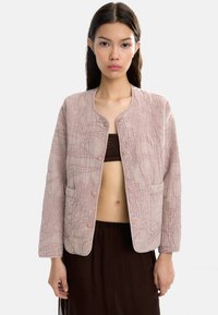 Jasnoróżowa kurtka zapinana na guziki z teksturowanym wzorem, okrągłym dekoltem i dwiema przednimi kieszeniami. Materiał wydaje się miękki i pikowany.