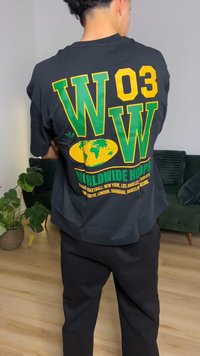 Juodi marškinėliai su dideliu geltonu ir žaliu užrašu "WOW", žemės rutulio dizainu ir užrašu "WORLDWIDE HOOPS" ant nugaros. Trumpomis rankovėmis.