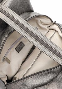 Silberne Lederhandtasche mit glatter Textur, Vorderreißverschluss und beigem Stoffinneren mit zusätzlichem Reißverschlussfach.