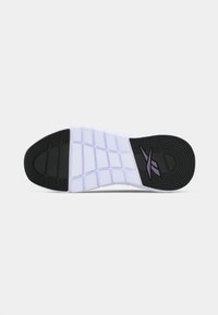 Sola de sapatilha atlética em preto e branco, apresentando um padrão de aderência texturizado e um design flexível com detalhes de marcação em roxo.