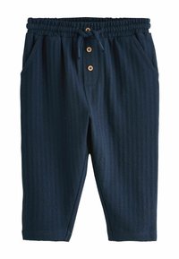 Pantaloni blu navy con design testurizzato a coste. Caratterizzati da un elastico in vita con coulisse e tre bottoni in legno. Dotati di tasche laterali.