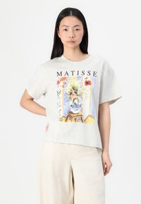 T-shirt de algodão cinza claro com uma impressão colorida de um vaso com flores de Matisse, com mangas curtas e um corte descontraído.