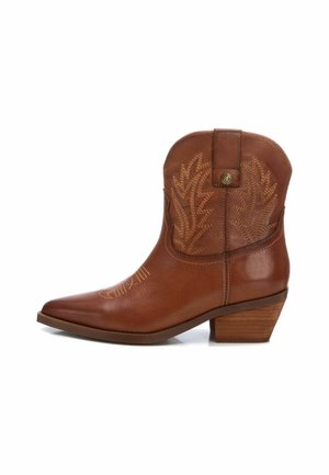 Bota de vaquero de cuero marrón con punta afilada, tacón bajo de madera y costura decorativa que asemeja hojas en el lado exterior.