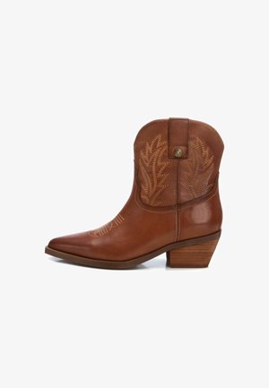 Bota de vaquero de cuero marrón con punta afilada, tacón bajo de madera y costura decorativa que asemeja hojas en el lado exterior.