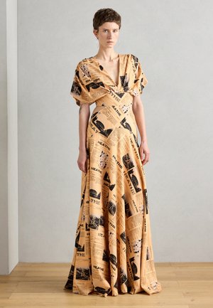Maxi dress made of lightweight fabric, featuring a peach background with black newspaper print. It has a deep V-neck and flutter sleeves.