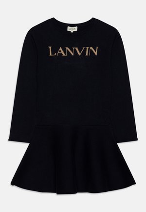 Musta neulemekko, jossa on pyöreä pääntie, pitkät hihat ja levenevä helma. "LANVIN" on kirjailtu kultaisin kirjaimin rinnan kohdalle.
