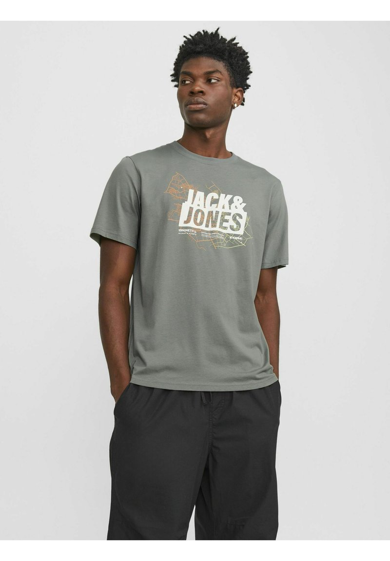 Camiseta de algodón gris con un estampado gráfico que incluye el texto "JACK & JONES" en blanco y amarillo, combinada con pantalones cortos negros.