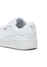 Bijele kožne tenisice s teksturiranim završetkom, s podstavljenim okovratnikom, ravnim vezicama i zlatnim akcentima Puma logotipa na boku i peti.