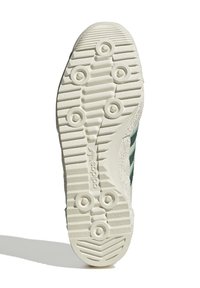 Vit sula på sportskor med texturerad yta, med cirkulära greppknoppar och tre gröna ränder på sidan. Hållbart material.