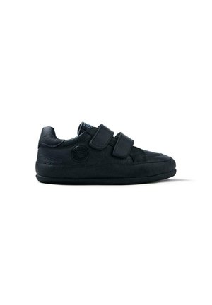 Baskets noires avec une tige en cuir texturé, deux lanières Velcro, bout rond et semelle en caoutchouc avec un détail de logo circulaire sur le côté.