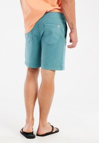 Turkooise denim shorts met een relaxed fit, voorzien van twee achterzakken, gestikte details en een zoom die boven de knie valt.