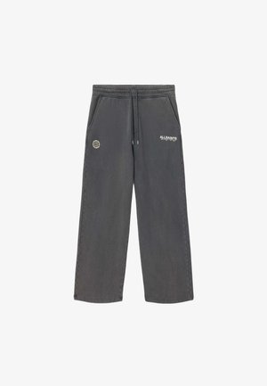 Sötétszürke, széles szárú melegítőnadrág rugalmas derékpánttal, húzózsinórral, oldalzsebekkel, valamint az elején kis fehér gömb- és márkalogókkal.