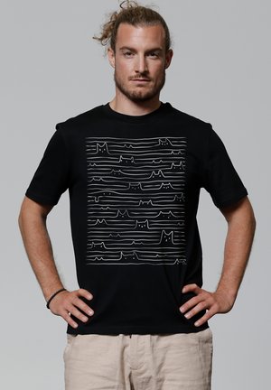 Zwarte katoenen T-shirt met een witte lijntekening van katten en abstracte golven op de voorkant. Korte mouwen en een ronde hals.