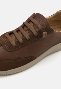 Braune Leder- und Wildledersneaker mit Schnürsenkeln, ausgestattet mit einer strukturierten Oberseite, gestickten Akzenten und einer beigen Gummisohle. KEEN-Logo auf der Zunge.