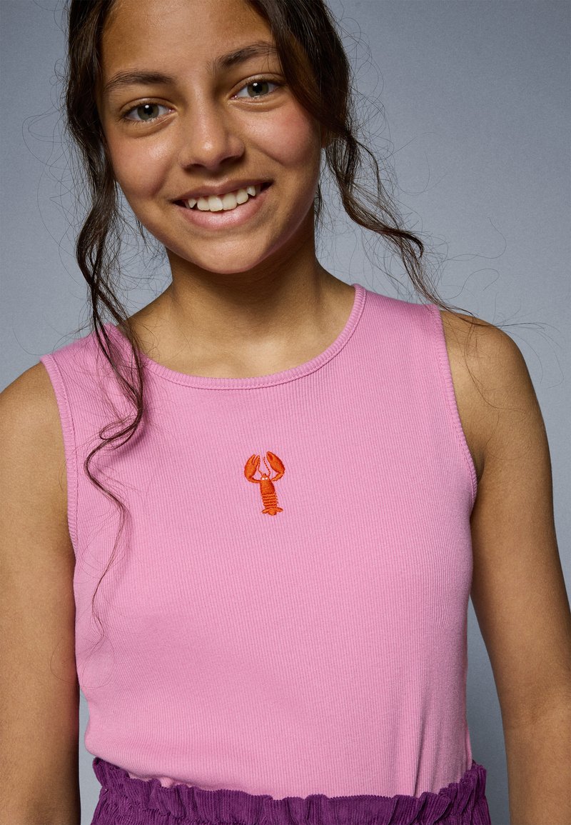 Rosa ribbet tank topp med detalj av en liten oransje hummer brodert; kombinert med en lilla volangbunn. Enkel og livlig fargekombinasjon.