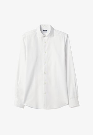 Chemise habillée blanche pour homme à manches longues, avec boutonnière sur le devant, col standard et poignets, présentée à plat sur un fond blanc.
