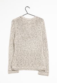 Vaaleanharmaa neulottu neulepaita, jossa on teksturoitu, avoin kudonta. Siinä on pyöreä kaula-aukko ja koristeelliset tikit helman ja hihansuiden kohdalla.