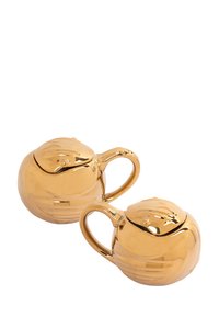 Due teiere in ceramica dorata lucida, di forma rotonda, con manici curvi e dettagli del coperchio che ricordano i petali di un fiore. Superficie liscia e riflettente.