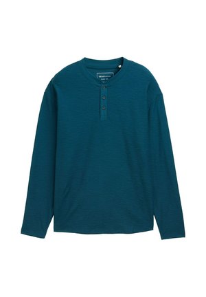 Camisa henley de manga larga en tejido de color verde oscuro texturizado, con cuello redondo y tapeta de tres botones. Diseño simple, sin patrones.