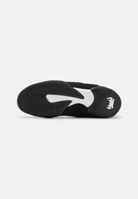 Schwarze Sport-Schuhsohle mit strukturiertem Gummi-Außensohle, die eine weiße Akzentfarbe und ein auffälliges Zickzackmuster für besseren Grip aufweist.