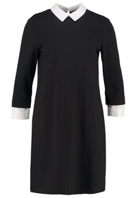 Zwarte jurk met lange mouwen, witte puntige kraag en witte manchetten, tot op de knie, eenvoudige en formele stijl.