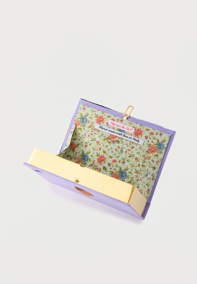 Μωβ τσαντάκι χειρός με χρυσό κούμπωμα, εσωτερικό με υφασμάτινα λουλούδια και ετικέτες που γράφουν "Olympia Le-Tan" και "Χειροποίητο με αγάπη στην Ιταλία".