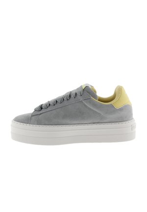 Zapatillas de ante gris con suela de goma blanca, que presentan un acento en el talón amarillo y cordones grises, con una puntera redondeada y un diseño texturizado.