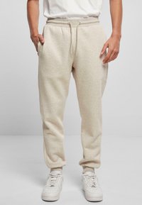 Beige sweatpants met elastische taille en trekkoord, voorzien van zijzakken en gekuifte enkels, gemaakt van zachte, gestructureerde stof.