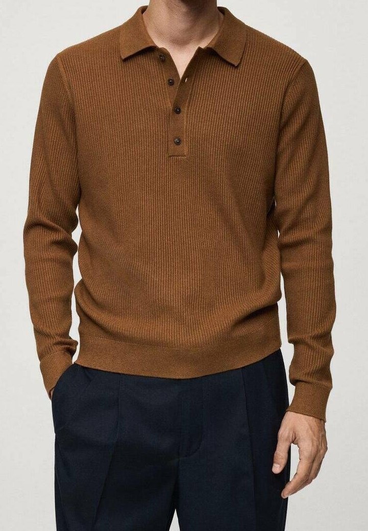Homme portant un pull polo marron côtelé à manches longues associé à un pantalon noir plissé, mains détendues le long du corps.