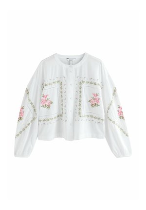 Weiße Bluse mit Knopfleiste und langen Ärmeln, verziert mit rosa Blumenstickerei und grünen Blattmustern entlang der Vorderseite und Ärmel.