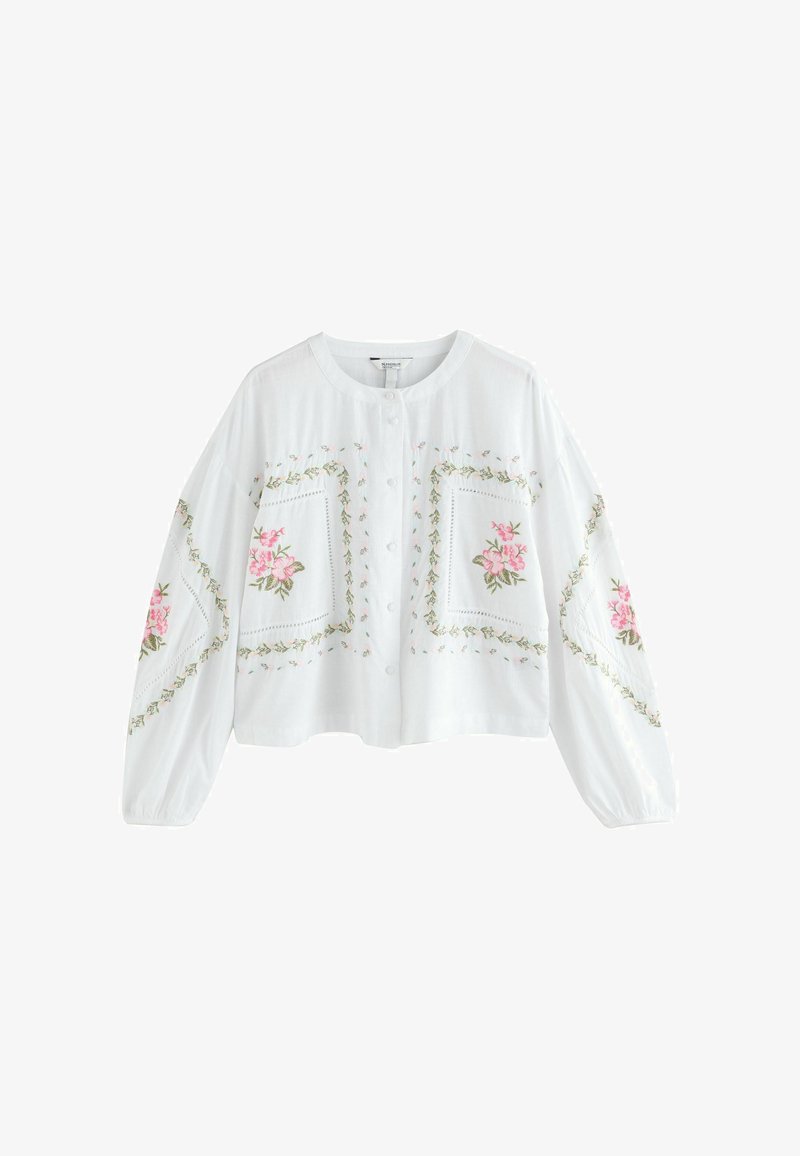 Blouse blanche à boutons avec manches longues, ornée de broderies florales roses et de motifs de feuilles vertes sur le devant et les manches.