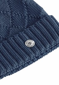 Marineblauwe gebreide muts met een gestructureerd patroon, voorzien van een geribde boord en een zilverkleurige logoknop. Zacht materiaal met een gladde afwerking.