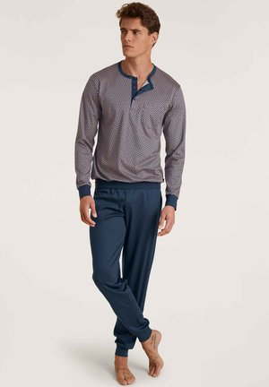 Haut de pyjama à manches longues en tissu à motifs bleu marine et blanc avec un col bleu et des boutons. Associe à un pantalon uni bleu marine. Texture douce.
