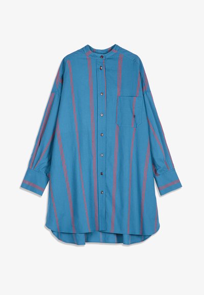 Blouse bleue à manches longues avec des rayures verticales rouges, boutonnée sur le devant, une poche poitrine unique et un ourlet arrondi, présentée sur fond blanc.