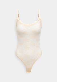 Lace bodysuit in cream with floral pattern. Features ruffled edges, adjustable straps, and a thong style bottom. Soft texture.