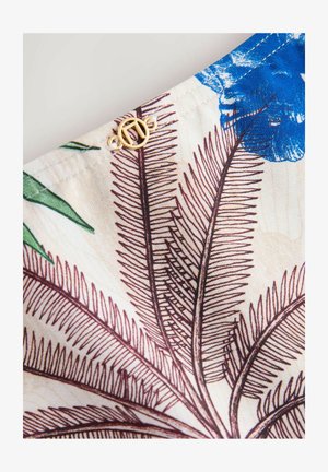 Blumiger Stoff mit blauen Blumen und braunen Farnblättern auf cremefarbenem Hintergrund. Goldene Metallapplikation am Rand. Weiche Textur.