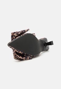 Leopardprint, blød stof, spidse tådesign, sort sål med tekstureret greb, og en sort accentrem ved hælen.