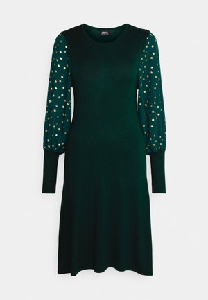 Green long-sleeve dress in soft fabric, featuring balloon sleeves with gold polka dots, round neckline, and a flared skirt.