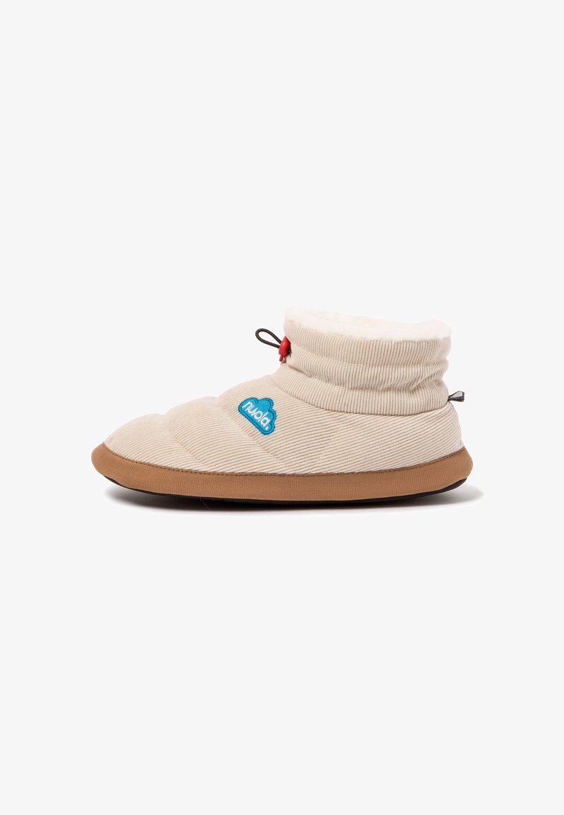 Zapatilla beige con un interior suave y acolchado y un exterior con rayas. Presenta un botón rojo y un logo de nube azul. Suela marrón. Diseño de corte bajo.