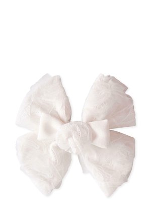 Biała kokarda z przezroczystego tiulu, z miękkimi, warstwowymi brzegami i węzłem w centrum. Akcenty obejmują delikatną, lekko falbaniastą teksturę.