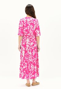 Maxikleid in leuchtendem Pink mit weißem Blumenmuster. Hat kurze Ärmel, eine geraffte Taille und einen gestuften Rock. Hergestellt aus leichtem Stoff.