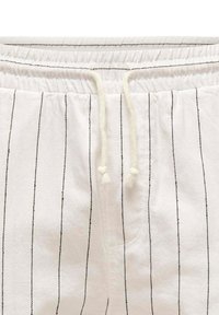 White fabric shorts featuring black vertical stripes, an elastic waistband with white drawstring, and a side pocket detail.