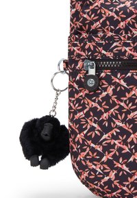 Borsa a fiori nera con foglie rosa e arancioni; presenta una cerniera e un portachiavi a forma di gorilla nero con una texture pelosa.