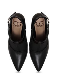 Chaussures en cuir noires à bouts pointus avec brides à la cheville et fermetures à boucle, marquées Cesare Gaspari à l'intérieur des semelles, vues de dessus.